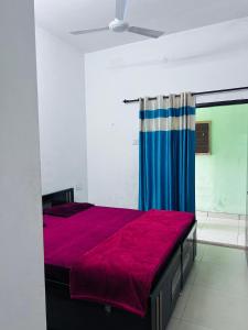 a bedroom with a bed with a red blanket at Delight Inn Guest House & PG in Lālewāl