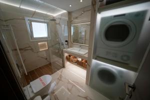 a bathroom with a toilet and a sink and a washing machine at POSEIDON Executive Suite in Athens