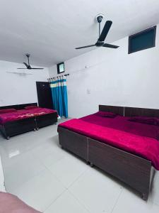 two beds in a bedroom with red sheets at Delight Inn Guest House & PG in Lālewāl