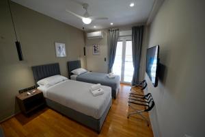 a hotel room with two beds and a television at POSEIDON Executive Suite in Athens