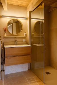 Un baño con lavabo y ducha con espejo. en Le Charmelan, en Barnas