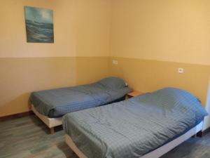 two beds in a room with yellow walls at Hôtel du petit verger in Saint-Germain-des-Prés