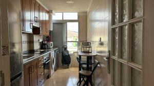 カンデラリアにあるAPARTAMENTO Ocean Elevenの木製のキャビネットとテーブルと椅子を備えたキッチン