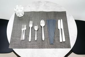 a table with silver utensils on top of a table at Tower View Stay Kinchicho in Wada