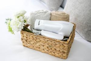 a basket with a hair dryer and flowers on a bed at Tower View Stay Kinchicho in Wada