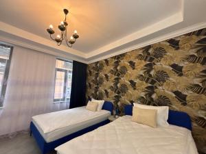 two beds in a room with a wall mural at Ferienwohnung Iridam in Jugelsburg