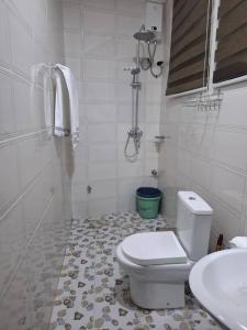 a white bathroom with a toilet and a sink at Jayda Lodge in Kwedonu +14 photos