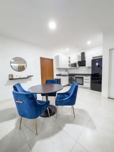 a dining room with blue chairs and a table at EasyStay Premier 2BDR Tribute House in Accra