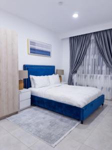 a bedroom with a blue bed and a window at EasyStay Premier 2BDR Tribute House in Accra