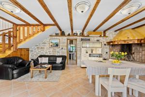 sala de estar con muebles de cuero y pared de piedra. en Villa Franz Krbune, en Potpićan