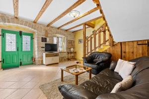 Una sala de estar con muebles de cuero y una puerta verde. en Villa Franz Krbune, en Potpićan