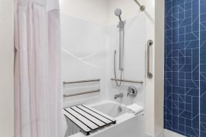 a bathroom with a tub and a shower with a sink at Spark by Hilton Essex Junction Burlington in Essex Junction