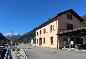 a building on a street next to a parking lot at Guest House alla Stazione, Ambrì in Ambri