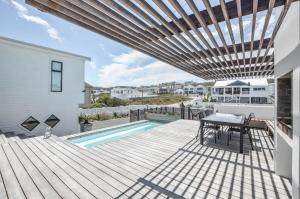 a patio with a table and a swimming pool at Sandbanks Villa in Yzerfontein
