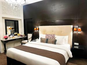 イスラマバードにあるHotel Margalaの大きなベッドと机のある寝室