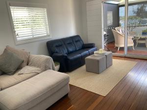 a living room with a couch and a table at Riverview Cottage in Dunbogan