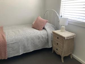 a small bedroom with a bed and a night stand at Riverview Cottage in Dunbogan +12 photos