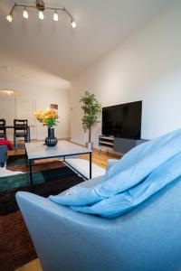 a living room with a blue couch and a tv at Large Central 2BR - Scandinavian Design - Balcony in Gothenburg
