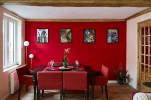 a red dining room with a black table and red chairs at cinéma immersif et chambres à thème dans le centre in Saint-Omer