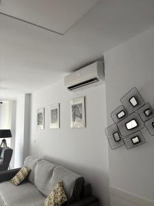 a living room with a couch and a air conditioner on a wall at Apartamento Plaza in Villajoyosa +35 photos