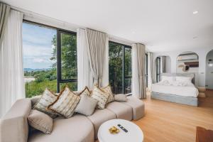 Una sala de estar con un sofá y una cama y grandes ventanales. en Leva Boutique Hotel, en Ko Samui 135 fotos más