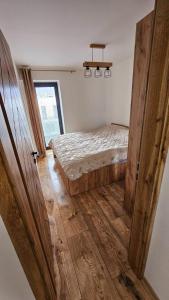 a bedroom with a bed and a wooden floor at Hron River View Apartment in Banská Bystrica