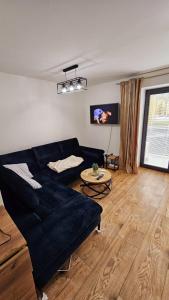 a living room with a black couch and a table at Hron River View Apartment in Banská Bystrica