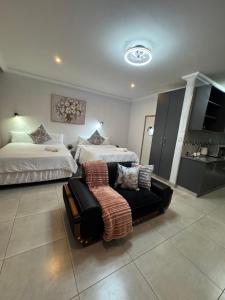 een slaapkamer met 2 bedden, een bank en een keuken bij WeMvula Guesthouse in Mtubatuba +31 foto's