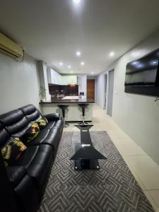 un salon avec un canapé en cuir et une table dans l'établissement Cloud Apartments 2 Bedroom in Lautoka CBD, à Lautoka