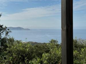 a view of the ocean from a house window at U pino in Lumio +7 photos