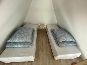 two twin beds in a small room with a table at Domki w Dąbkach in Dąbki +35 photos