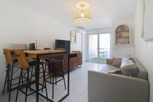 a kitchen and living room with a table and a couch at Le Nid du Pradon in Cavaillon