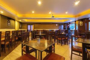 a restaurant with tables and chairs in a room at Hotel Vivek in Coonoor