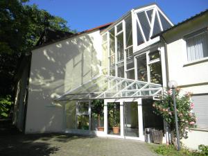ein großes weißes Gebäude mit Glasdach in der Unterkunft Hotel Landgut Burg GmbH in Weinstadt