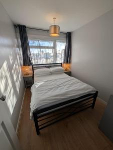 ein Schlafzimmer mit einem Bett mit einem Fenster und zwei Lampen in der Unterkunft 88, Belle Aire, Hemsby - Two bed chalet, sleeps 5, bed linen and towels included - pet friendly in Great Yarmouth