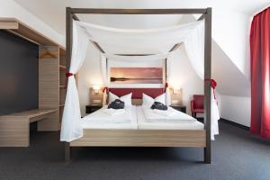 a bedroom with a bed with a canopy at Hotel Sonnenhof Pleinfeld in Pleinfeld