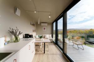 cocina y sala de estar con vistas a un balcón en Coniferis, en Tomnatic