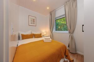 a bedroom with a bed with an orange blanket at Hygge Tiny House 1 - Berlin Brandenburg in Berlin