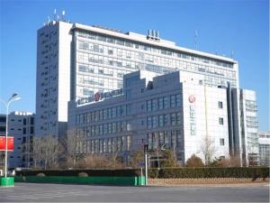 a large building with a sign on top of it at Jinjiang Inn Tianjin Haitai Industrial Parks in Tianjin