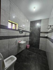 um banheiro com vaso sanitário, pia e chuveiro em Nature's Frame Residency em Varkala mais 6 fotografias