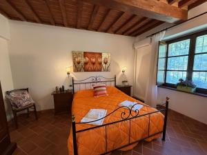 a bedroom with an orange bed in a room with windows at Alma del Lago - Charming Apartments- il Carpignone in La Pesta +105 photos