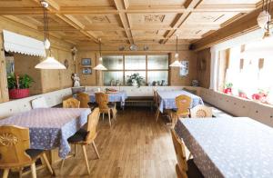 a restaurant with blue tables and chairs and windows at Hotel Pensione Veneranda in Corvara in Badia