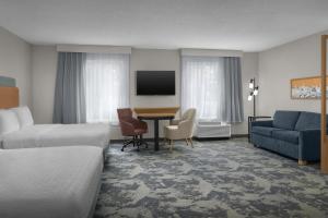 a hotel room with a bed and a desk and a couch at Hampton Inn & Suites Huntersville in Huntersville