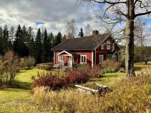 HerrängLilla Älva的田间中的一个红色房子