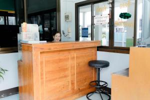 una mujer sentada en el mostrador de un restaurante en Thongkon Hotel, en Surin