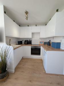 une cuisine blanche avec des armoires blanches et un évier dans l'établissement 288 Belle Aire, Hemsby - Beautifully presented two bed chalet with veranda, sleeps 5, pet friendly, free Wi-Fi, bed linen and towels included and onsite entertainment available, à Hemsby