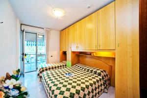 - une chambre avec 2 lits et des placards en bois dans l'établissement Auriga del Sole, à Bibione