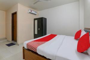 a bedroom with a large bed with red pillows at FabHotel Raas Inn in Lucknow +22 photos