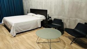 a bedroom with a bed and two chairs and a table at Lake Breeze Cabana Yala in Tissamaharama