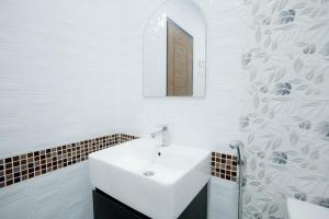 Un baño blanco con lavabo y espejo. en Thongkon Hotel, en Surin 40 fotos más